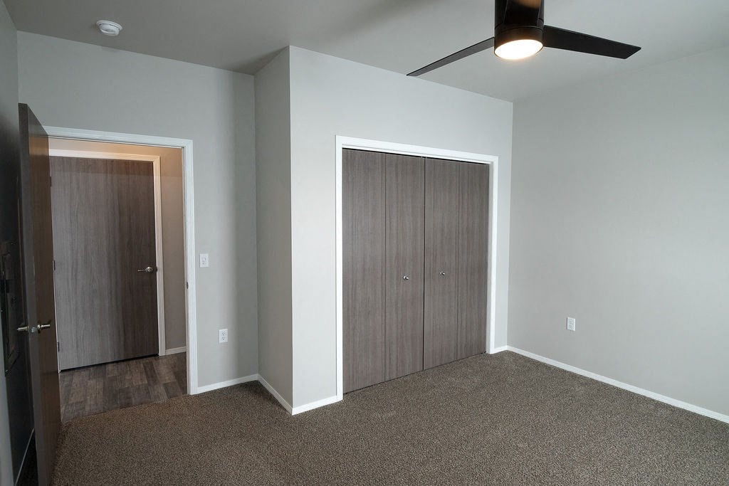 a bedroom with a closet and a ceiling fan