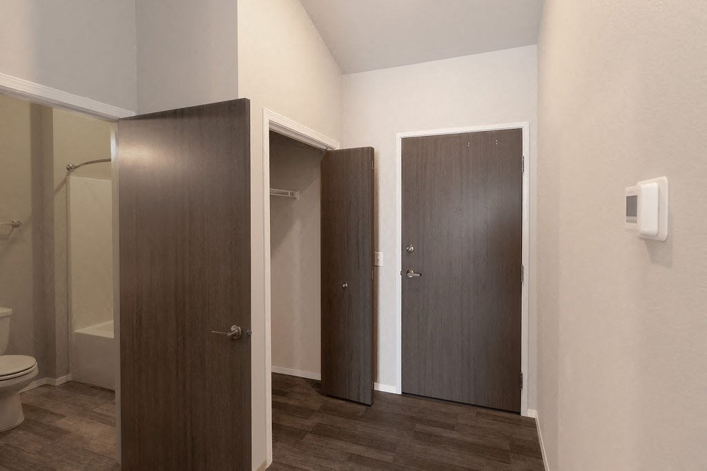 a bathroom with a toilet and two doors