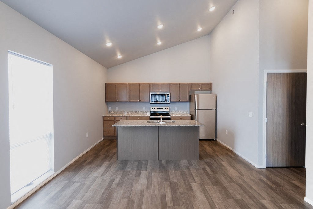 a kitchen with stainless steel appliances and wooden floors