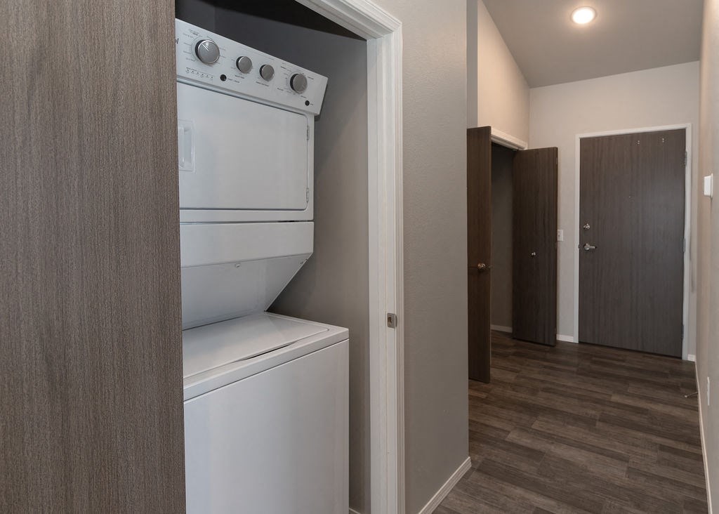 a white washer and dryer in a room with a hallway and a door