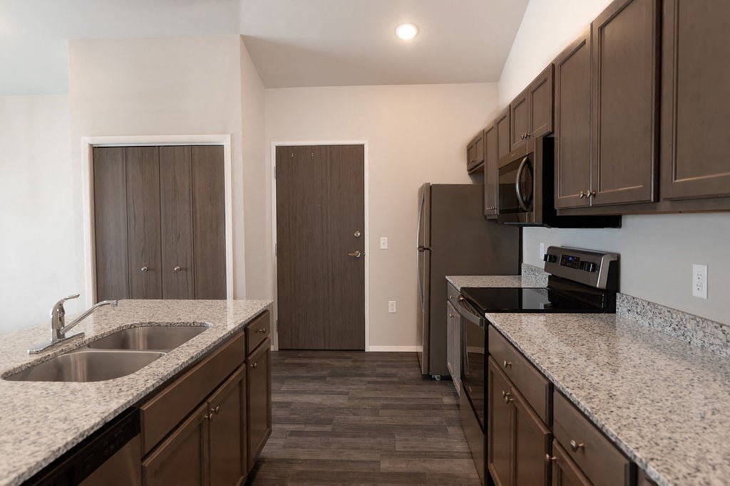 a kitchen with granite counter tops and wooden cabinets