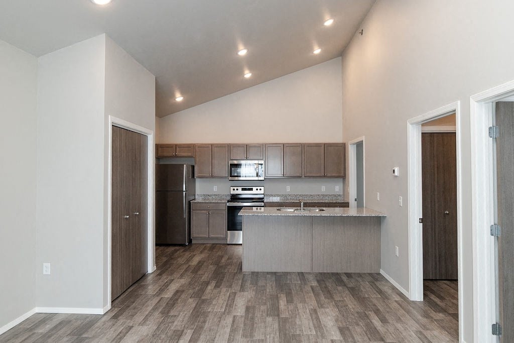 a kitchen with stainless steel appliances and a wooden floor