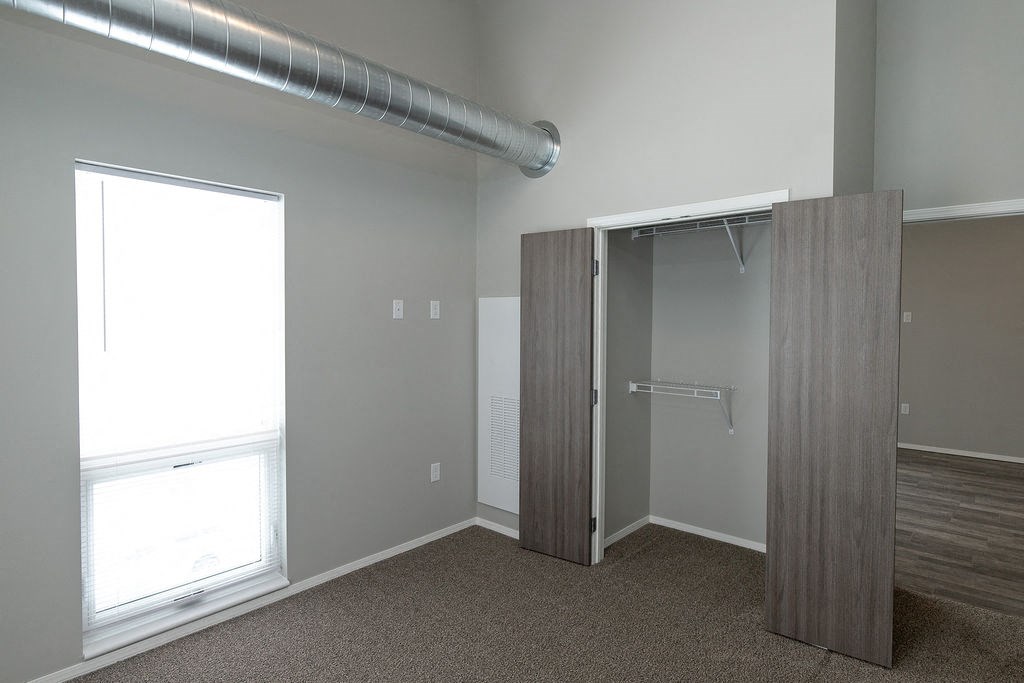 an empty room with a closet and a window