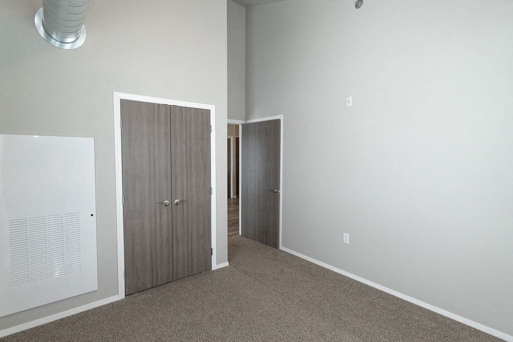 a bedroom with a closet and a door to a hallway
