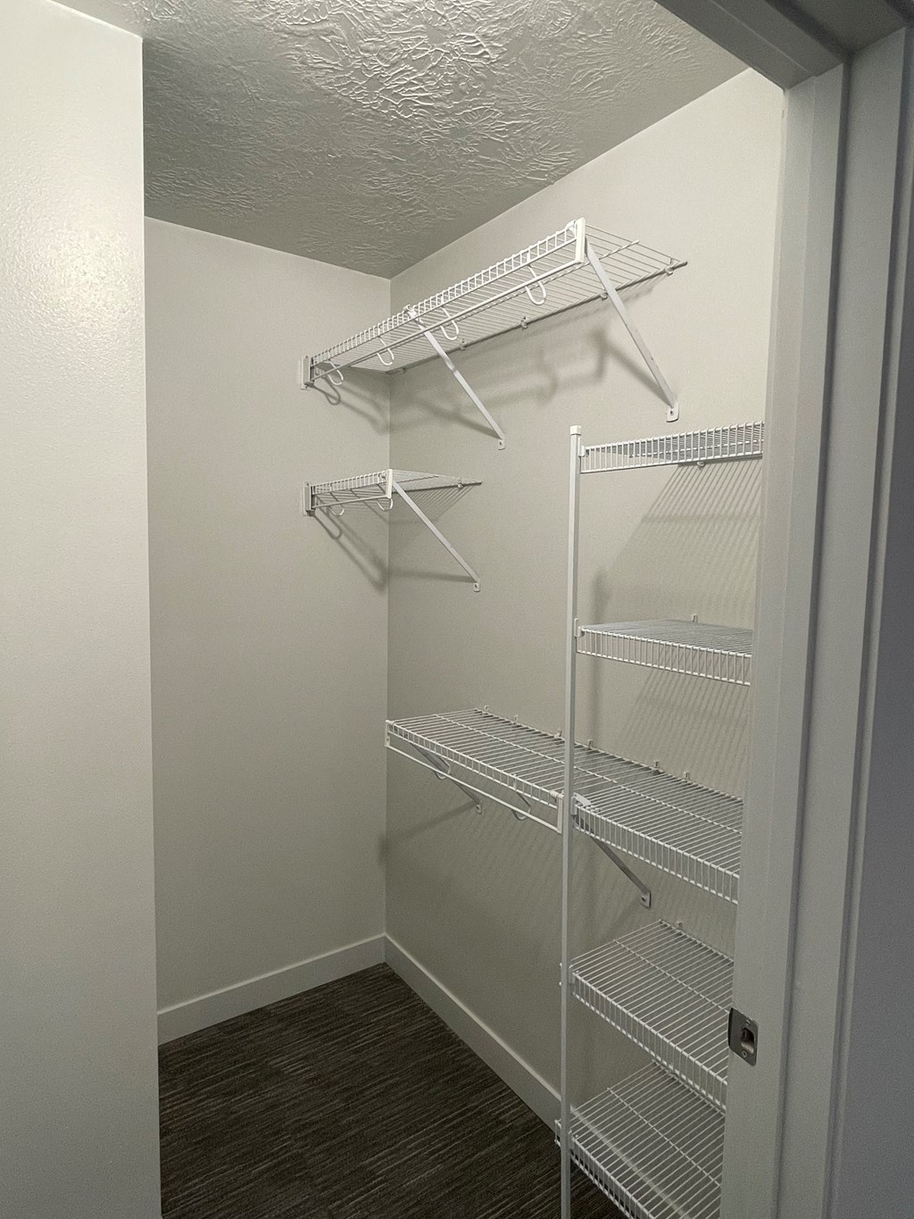 A white closet with shelves and hangers.