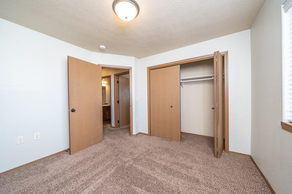 a bedroom with two closets and a door to a bathroom