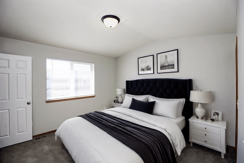 A bedroom with a large bed and two nightstands.