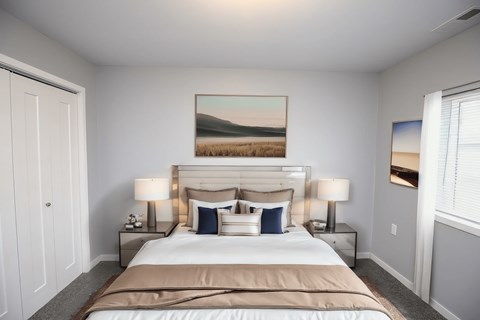 A bedroom with a large bed and a painting on the wall.