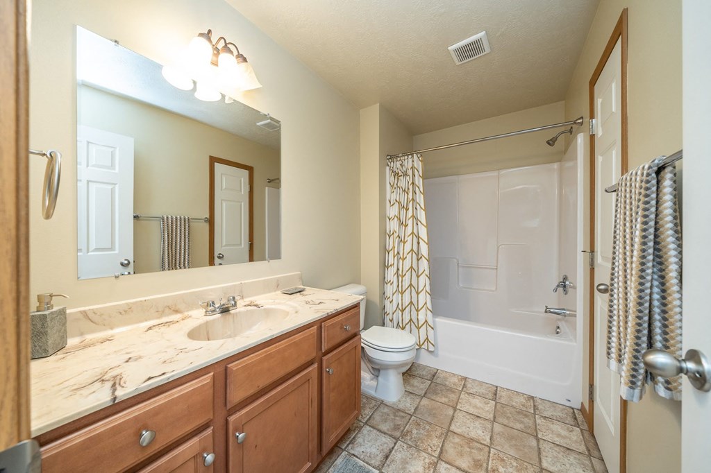 a bathroom with a shower toilet and sink and a mirror