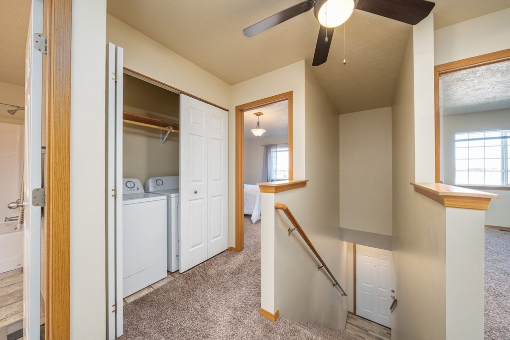 a laundry room with a washer and dryer and a stairway to a