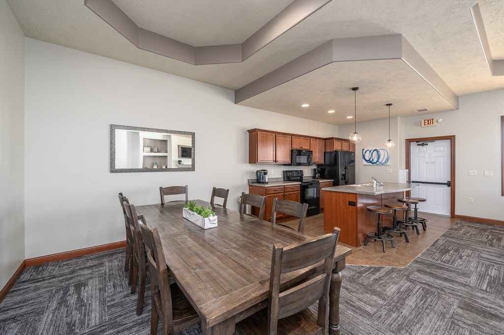 a dining room and kitchen with a wooden table and chairs