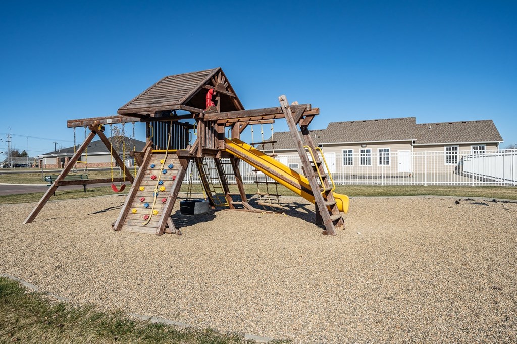 a swing set in a yard with a house in the background