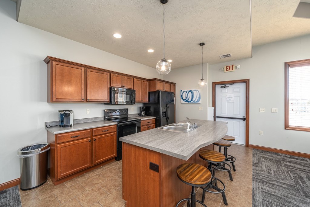 a kitchen with a marble counter top and wooden cabinets