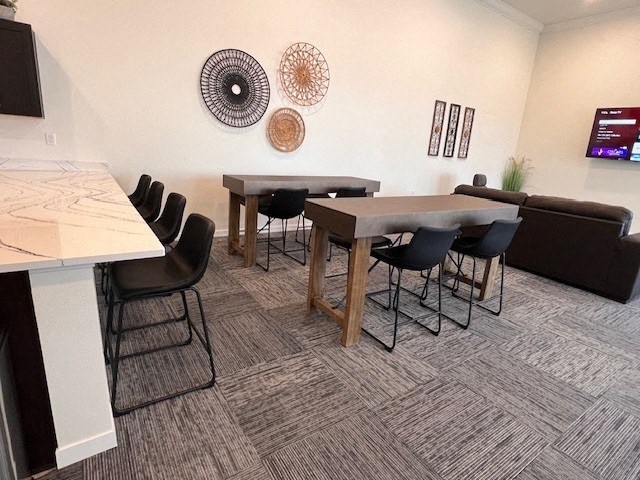 a living room with tables and chairs and a television
