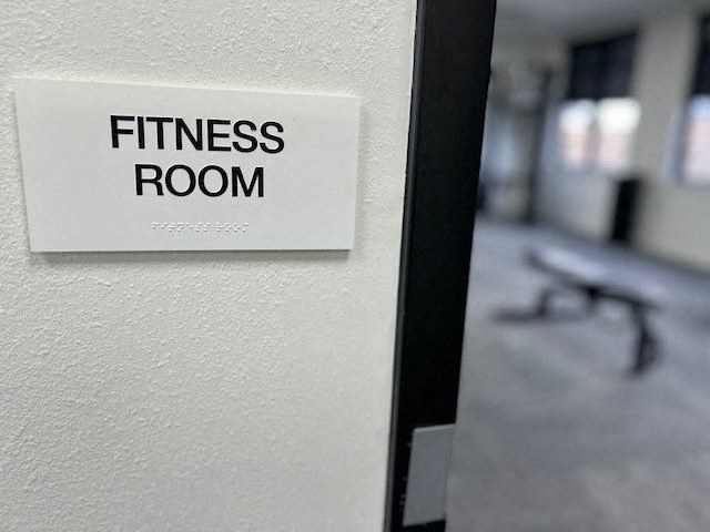 a fitness room sign on a white wall