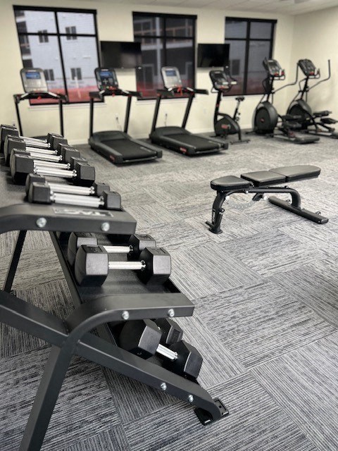 a fitness room with weights and other exercise equipment