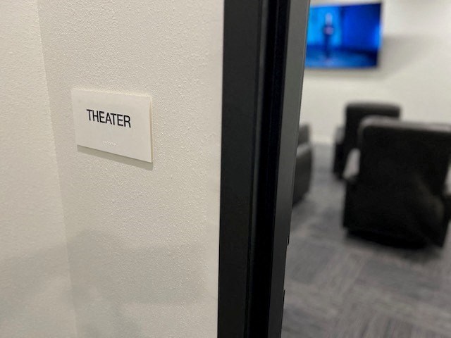 a theater room with a sign on the door