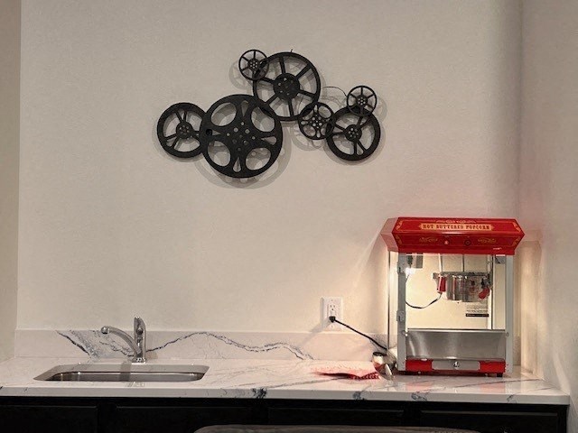 a kitchen counter with a coffee maker and some wheels on the wall