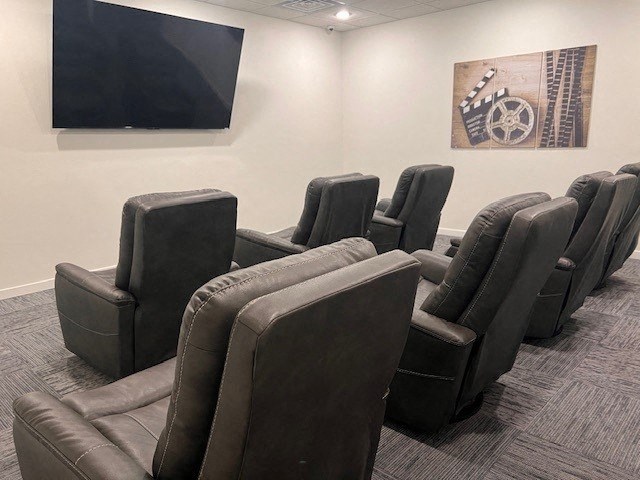 a group of leather chairs in a room with a tv