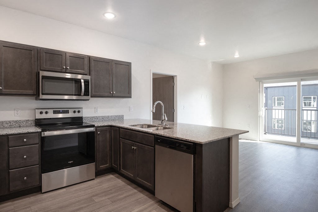 a kitchen with a granite counter top and stainless steel appliances