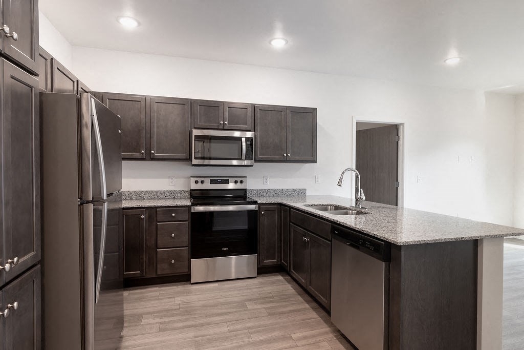 a kitchen with dark wood cabinets and stainless steel appliances