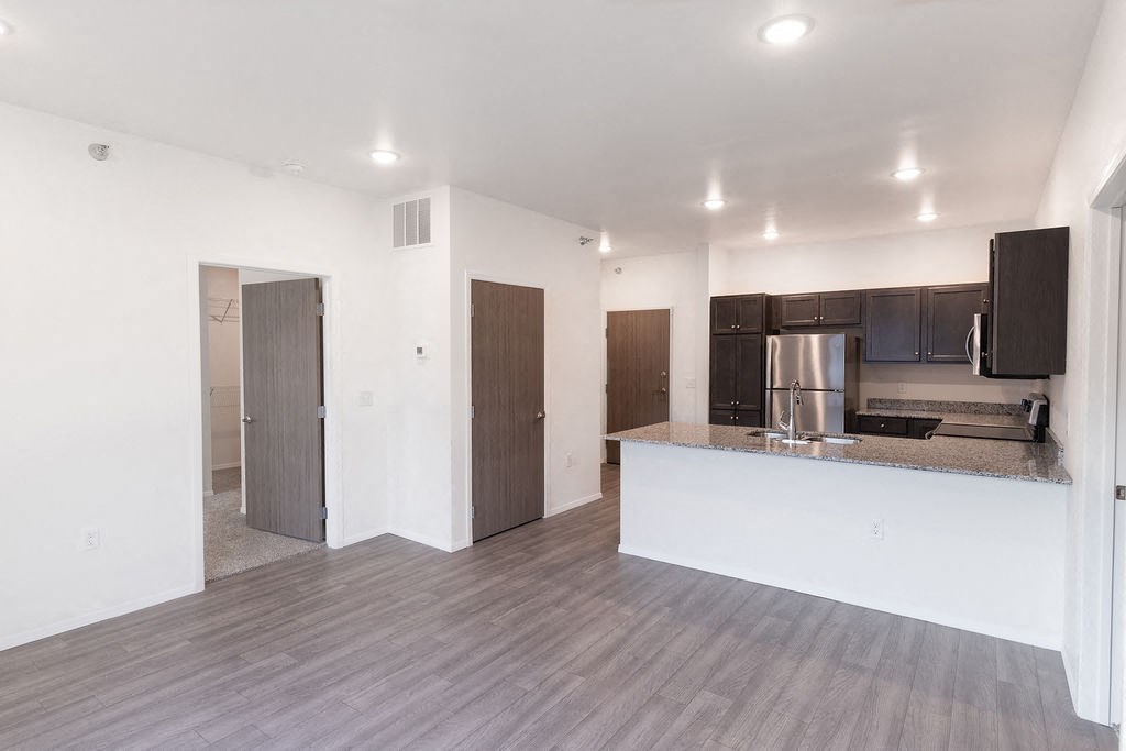 an empty living room and kitchen with a counter top and