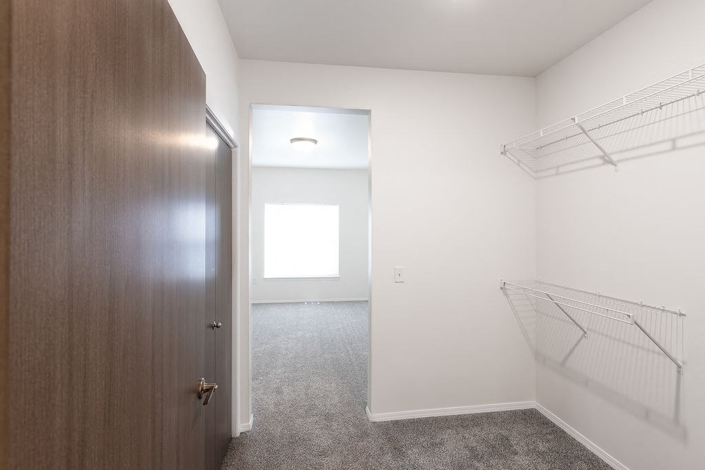 a bedroom with a closet and a door to a room