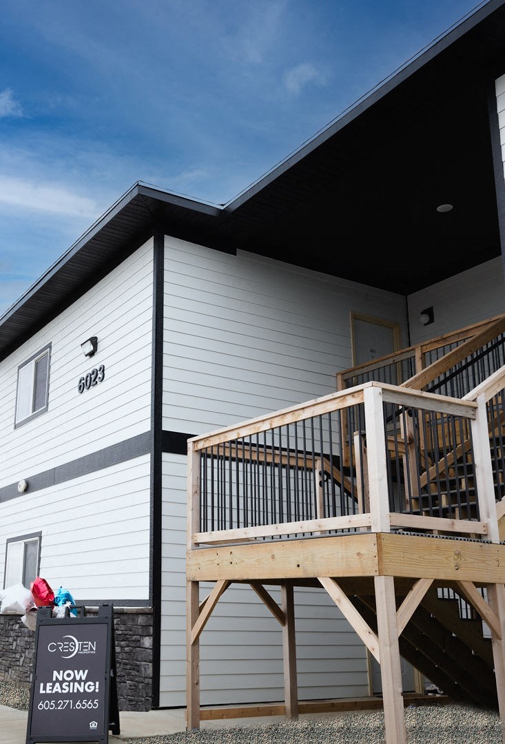 the front of a house with a wooden deck
