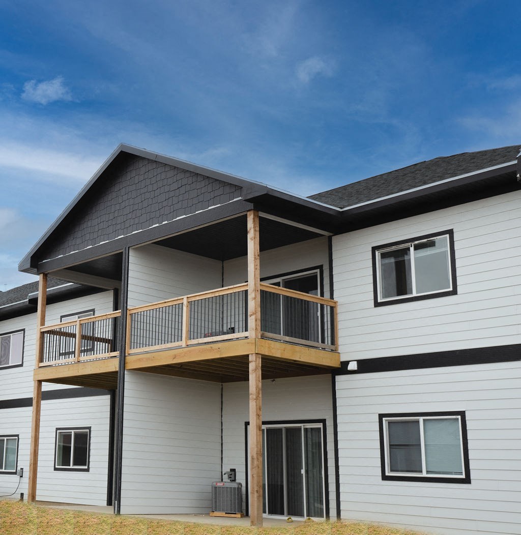 a white house with a balcony and a blue sky