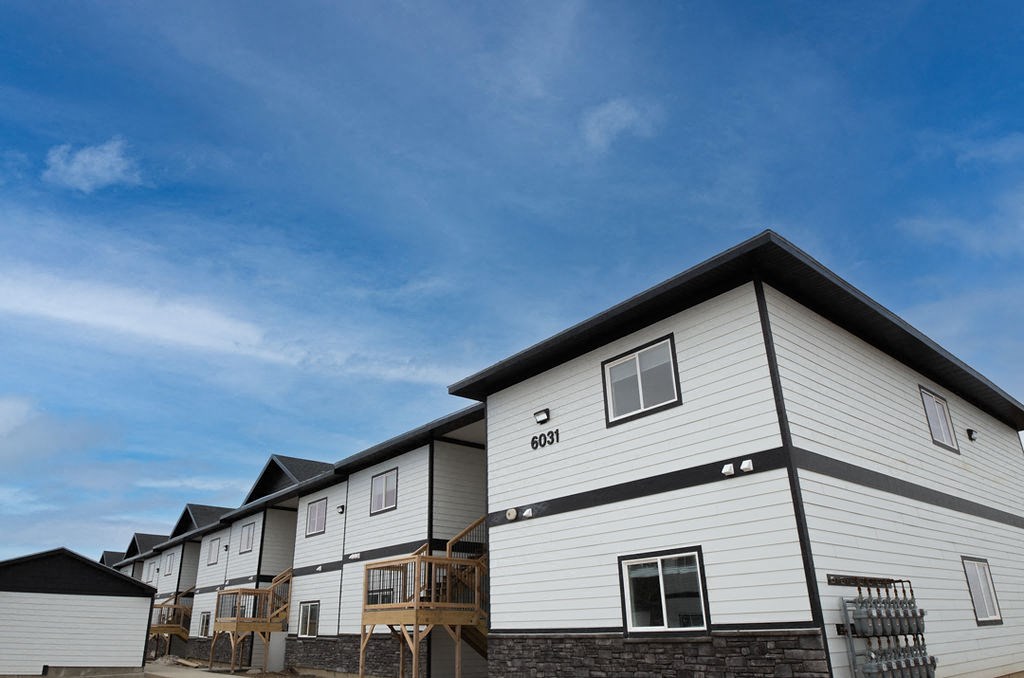 a row of houses with a blue sky in the background