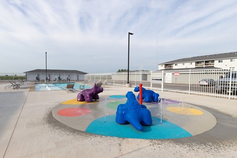 A playground with a purple elephant and blue bear on the ground.