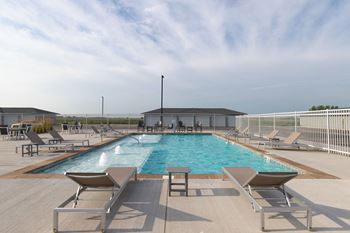 a swimming pool with chairs around it at a resort