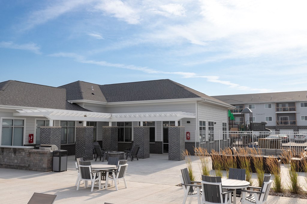 a patio with tables and chairs in front of a building