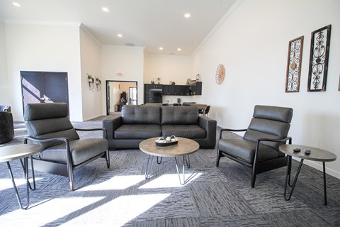 A living room with a grey couch, two chairs and a coffee table.