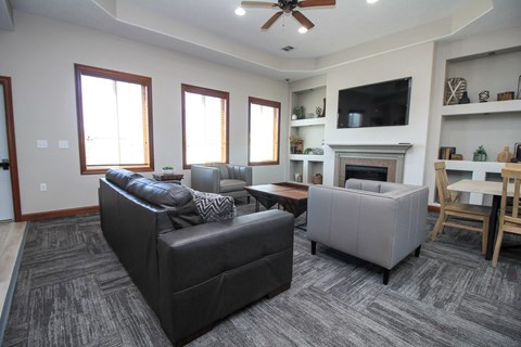 A living room with a grey couch and a fireplace.