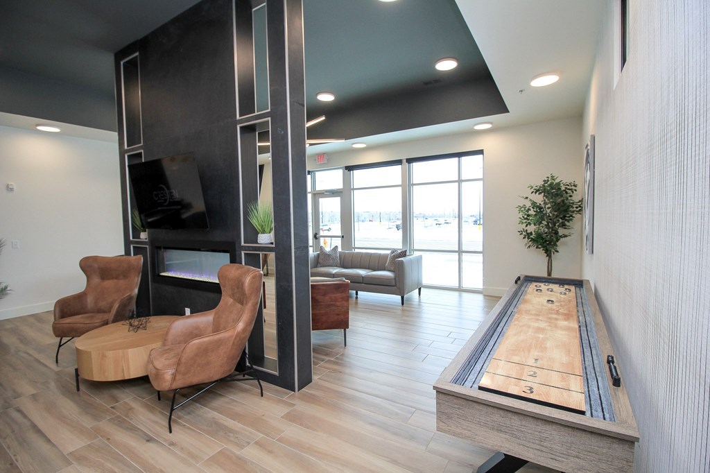 A room with a shuffleboard table and a fireplace.