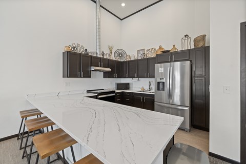 A kitchen with a marble countertop and stainless steel appliances.