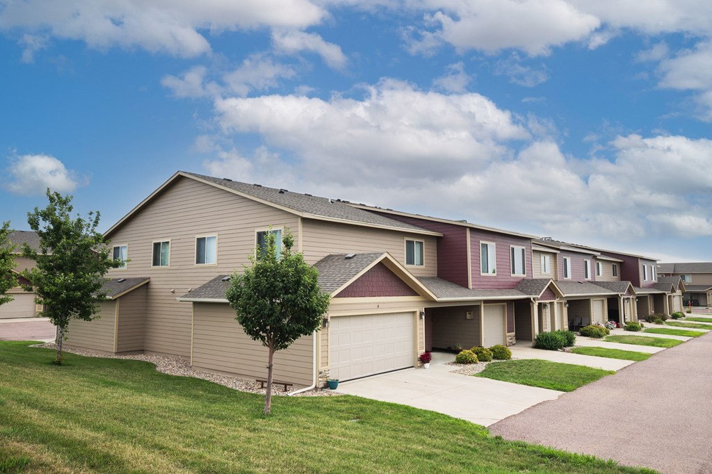 a row of houses on a street with a sidewalk