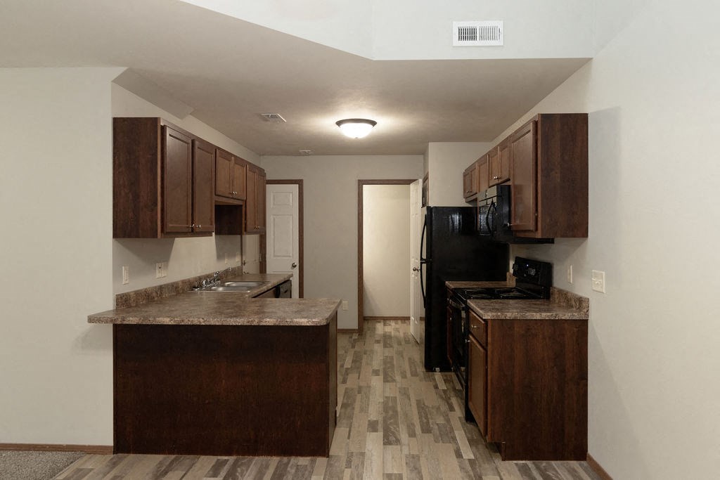 a kitchen with wooden cabinets and counter tops in a room