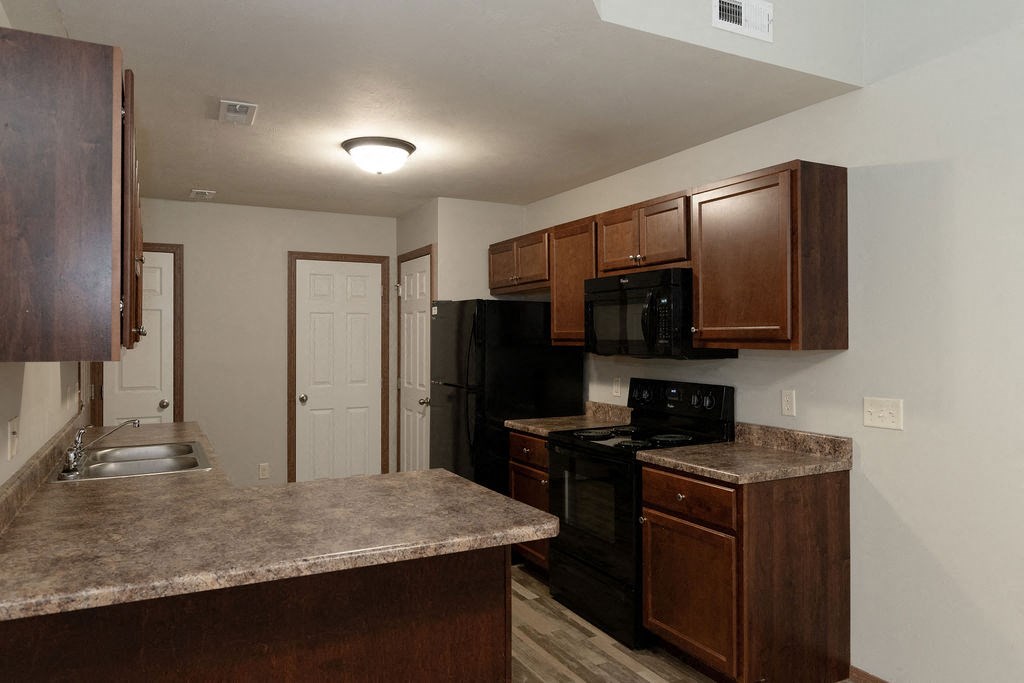 a kitchen with marble counter tops and wooden cabinets