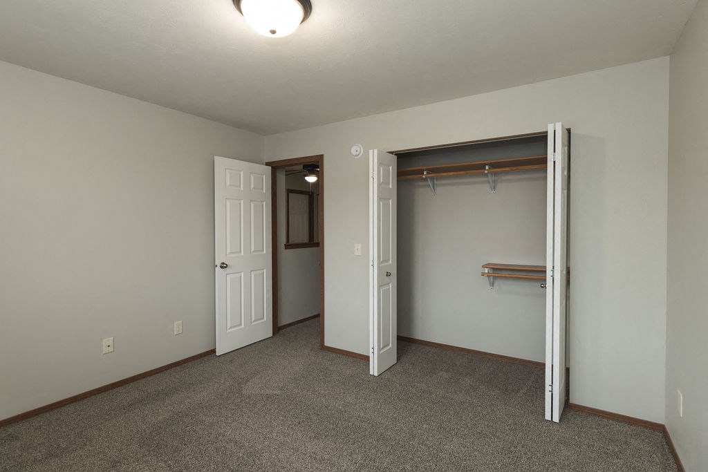 a bedroom with a closet and a door to a bathroom