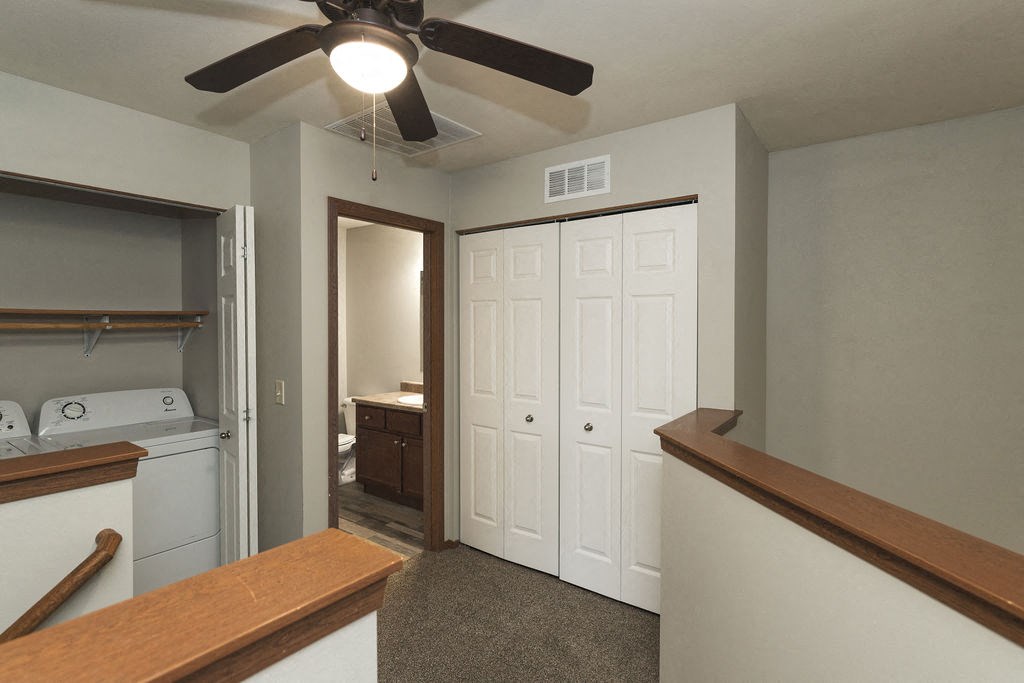 a kitchen with white cabinets and a ceiling fan