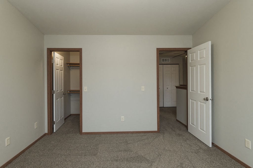 a bedroom with a door open to a hallway and a closet