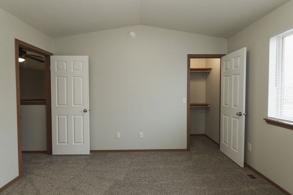 a bedroom with two closets and a door to a closet