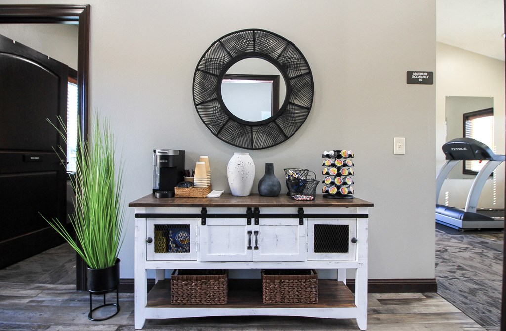A white table with a mirror above it and a plant to the left.