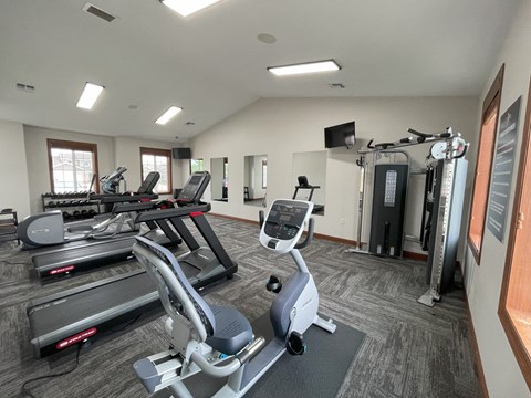 A gym with treadmills, elliptical machines, and other exercise equipment.