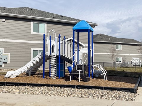 A playground with a blue structure and a slide.