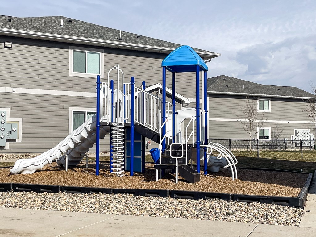 A playground with a blue structure and a slide.