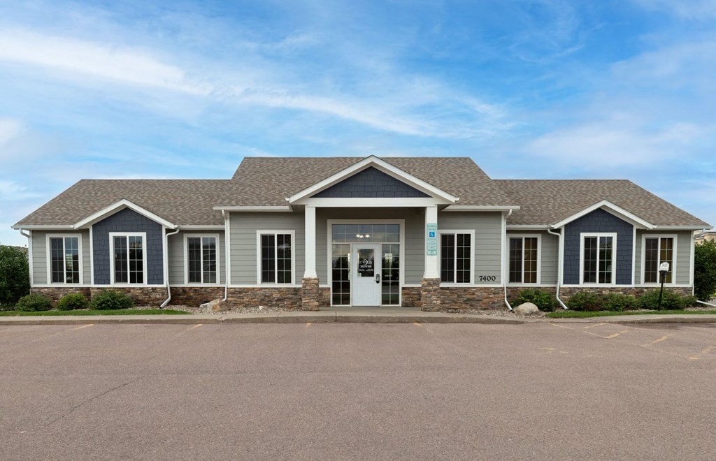 the front of a house with a large driveway and a roof