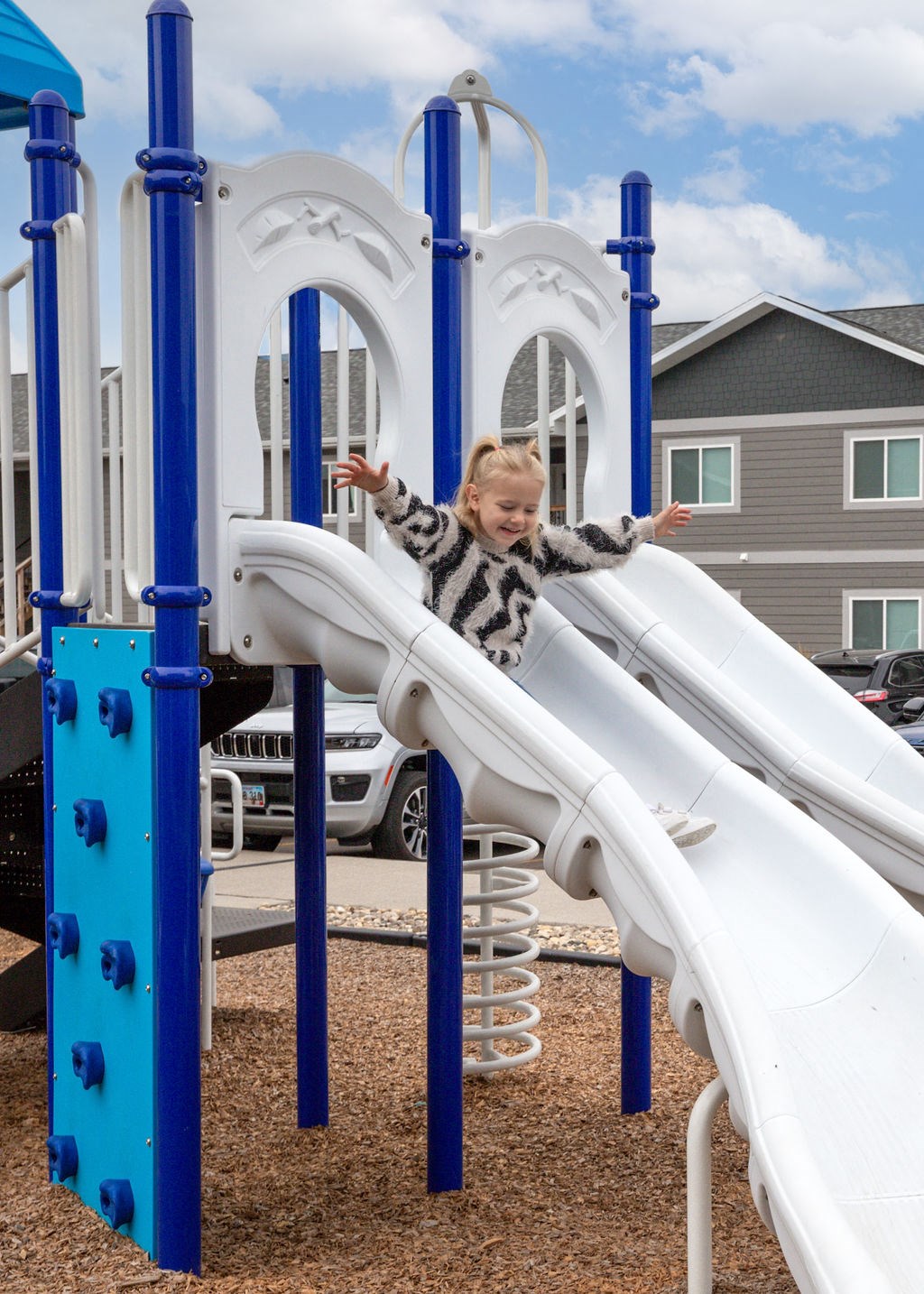 a young child sliding down a slide at a park